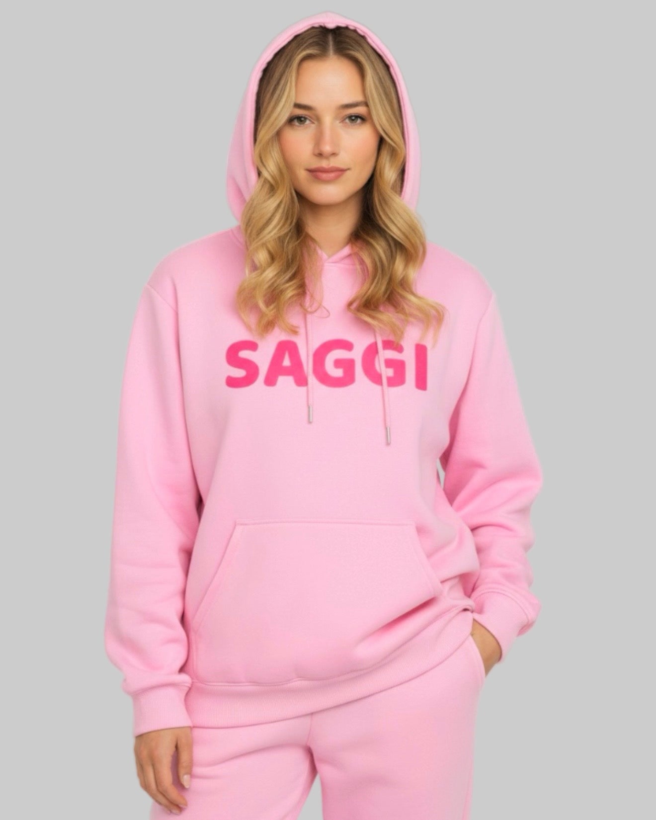 Model wearing pink SAGGI heavyweight graphic hoodie with fuchsia logo and pink drawstrings, true-to-size fit.