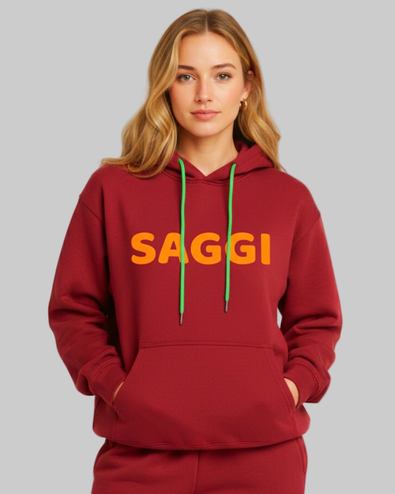 Model wearing burgundy SAGGI heavyweight graphic hoodie with orange logo and green drawstrings, true-to-size fit.
