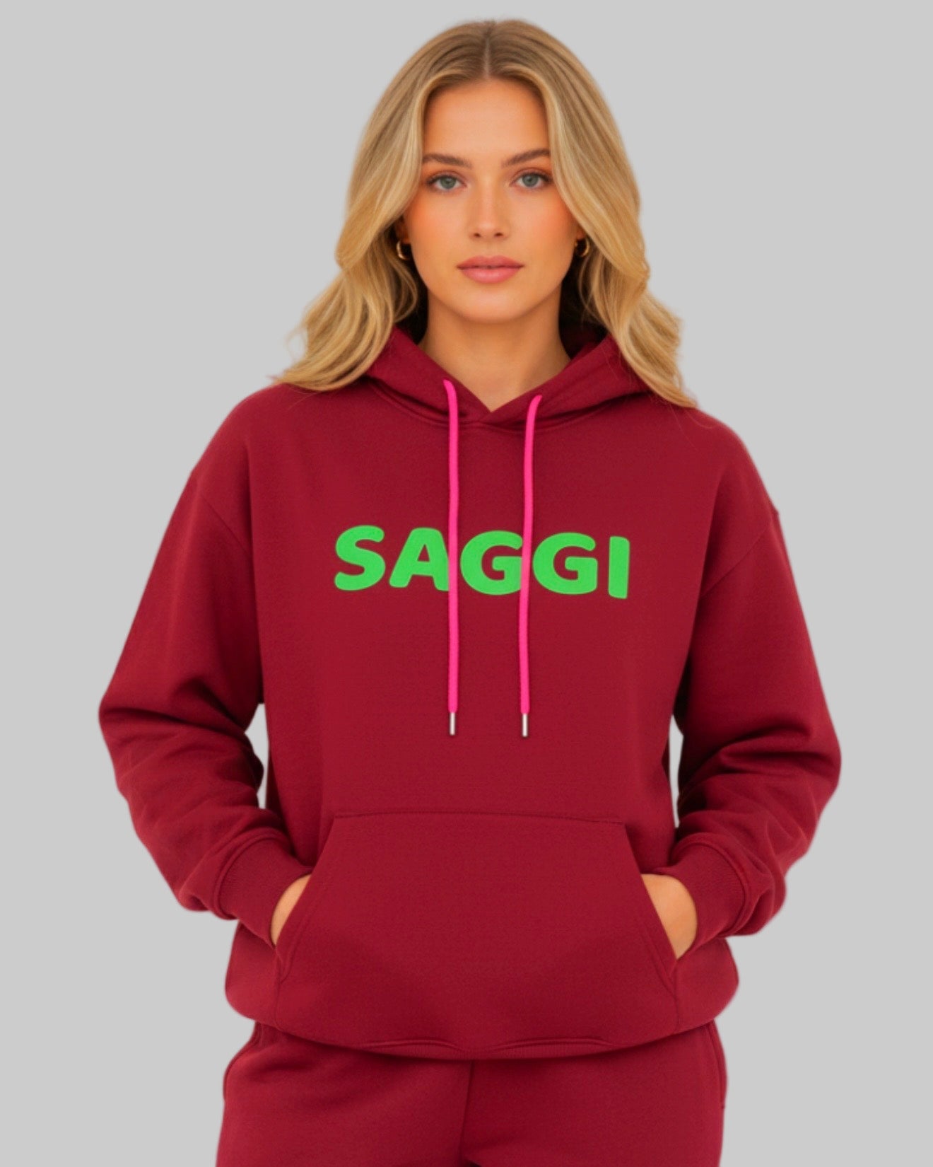 Model wearing burgundy SAGGI heavyweight graphic hoodie with green logo and fuchsia drawstrings, true-to-size fit.