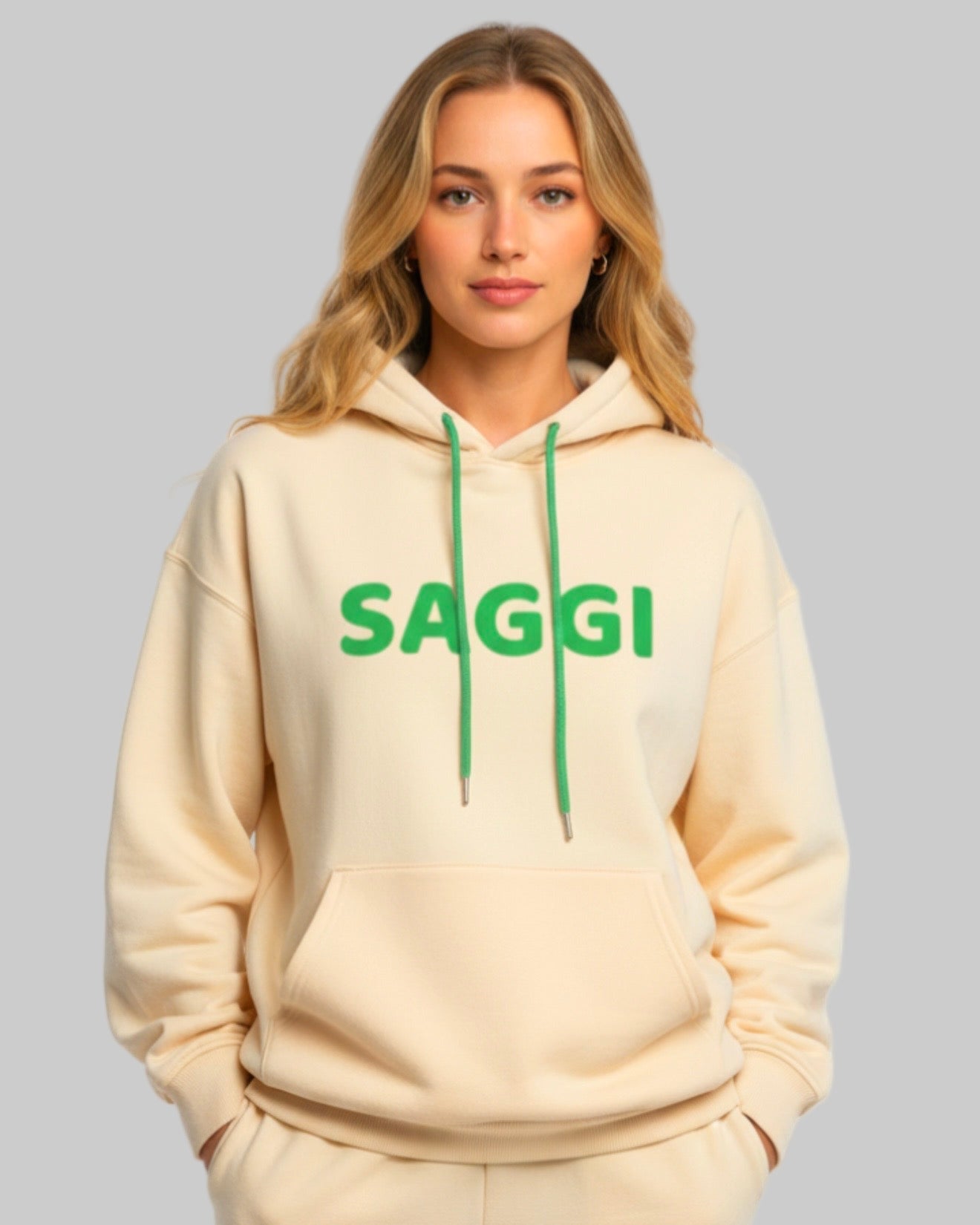 Model wearing khaki SAGGI heavyweight graphic hoodie with green logo and green drawstrings, true-to-size fit.