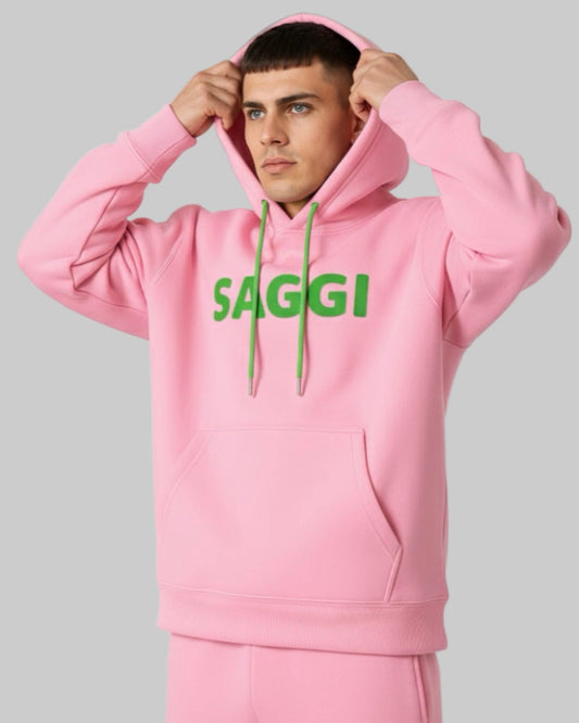 Model wearing pink SAGGI heavyweight graphic hoodie with green logo and green drawstrings, true-to-size fit.
