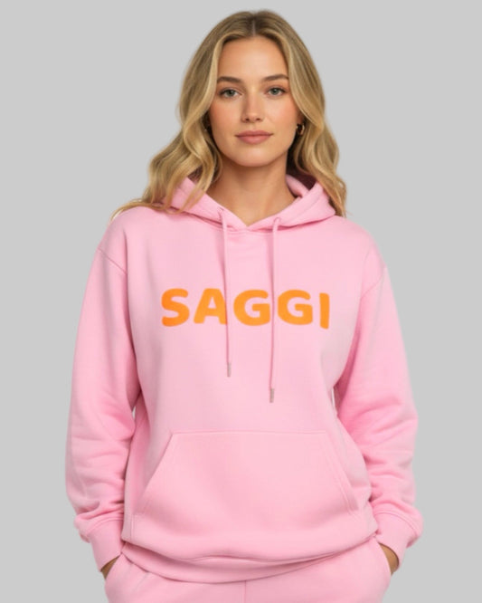 Model wearing pink SAGGI heavyweight graphic hoodie with orange logo and pink drawstrings, true-to-size fit.