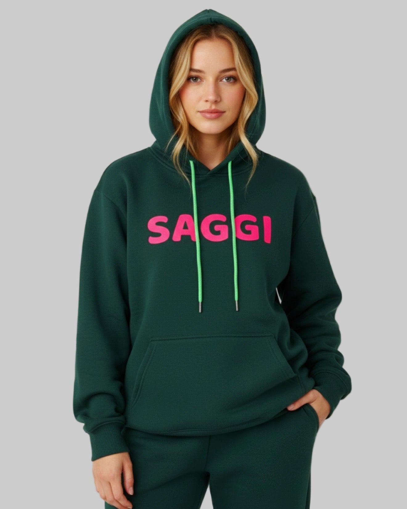 Model wearing forest green SAGGI heavyweight graphic hoodie with fuchsia logo and green drawstrings, true-to-size fit.